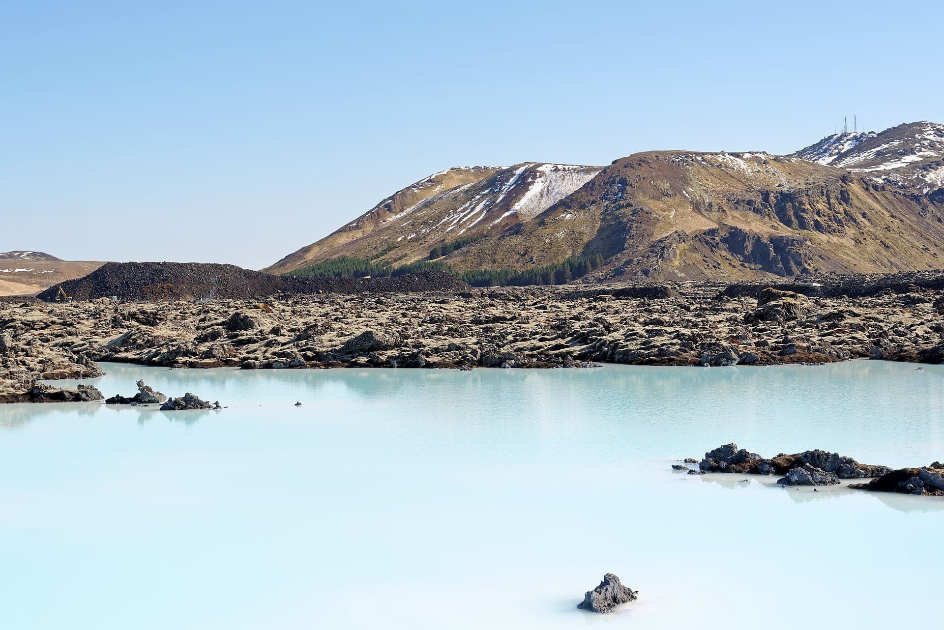 Milky blue geothermal water of the Blue Lagoon amid a black lava field