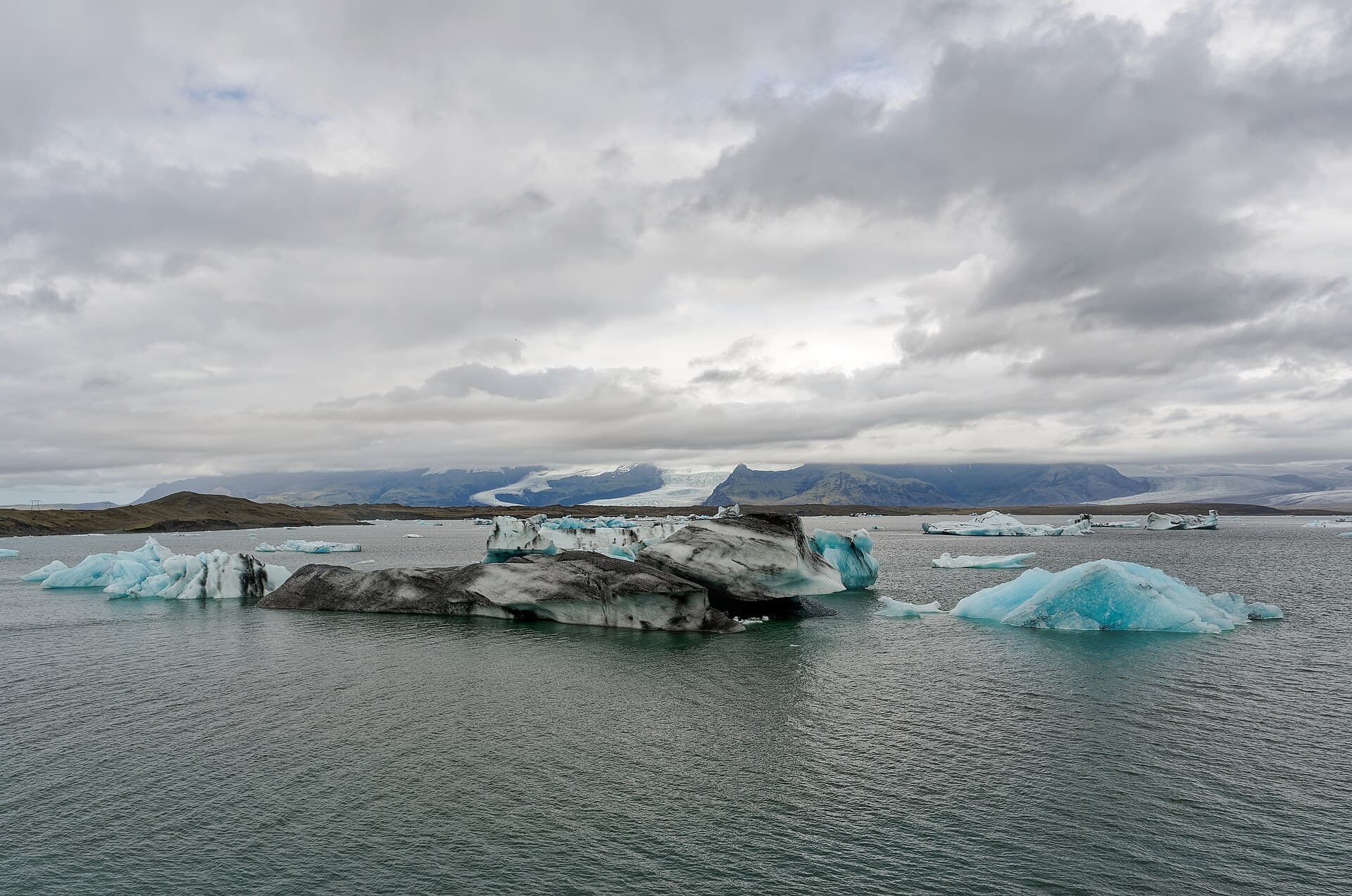 Icebergs drifting in Jökulsárlón glacier lagoon with the ice cap behind